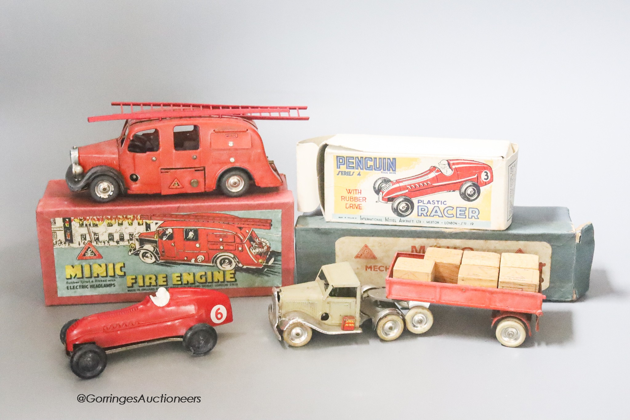 A Tri-ang Minic pre-war mechanical horse and tractor, a Tri-ang Minic fire engine and a penguin racer, boxed